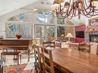 This stunning property boasts a spacious dining area with a large wooden table and chairs, perfect for hosting gatherings.