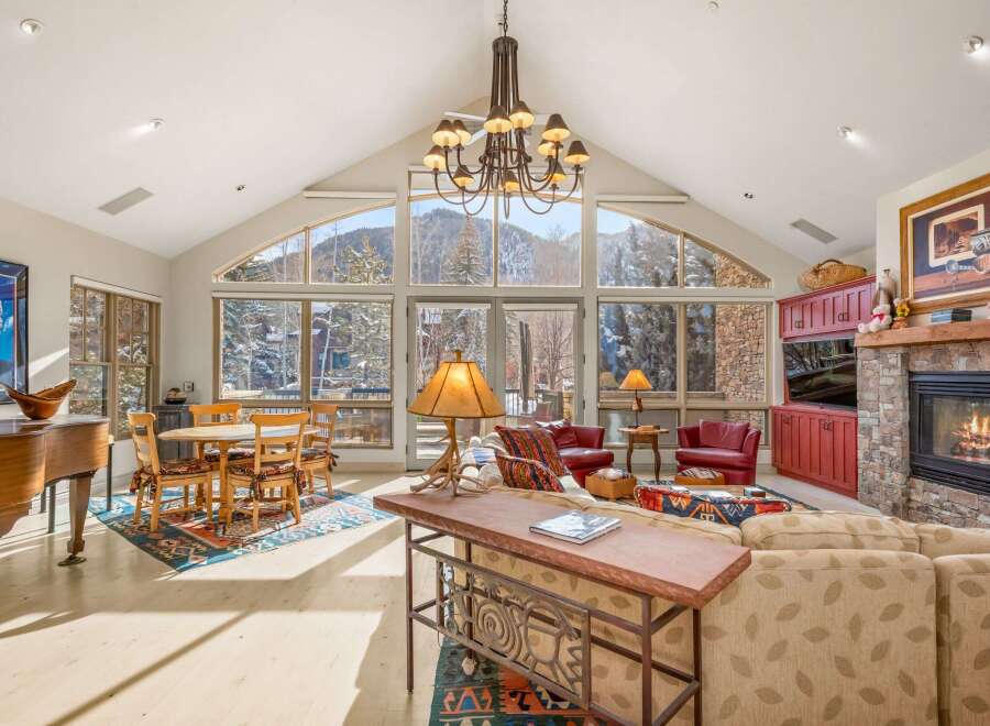 Experience luxury living in this stunning property featuring a grand living room with a soaring ceiling and breathtaking mountain views.