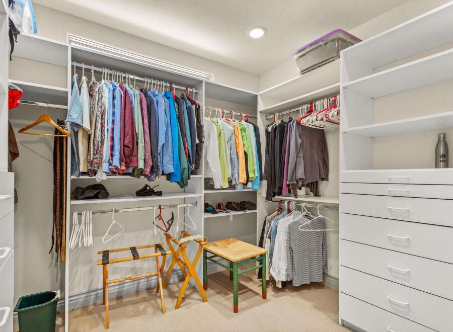 Step into luxury with this meticulously organized walk-in closet, offering ample space for your wardrobe.