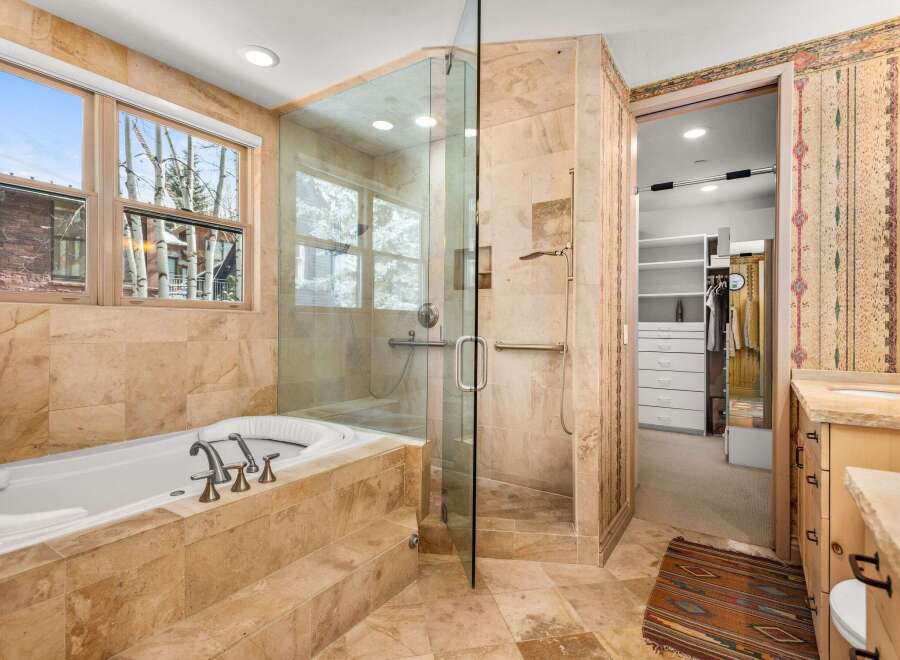 Indulge in luxury within this stunning bathroom, featuring a spacious walk-in shower and a relaxing jacuzzi tub.