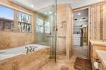 Indulge in luxury within this stunning bathroom, featuring a spacious walk-in shower and a relaxing jacuzzi tub.