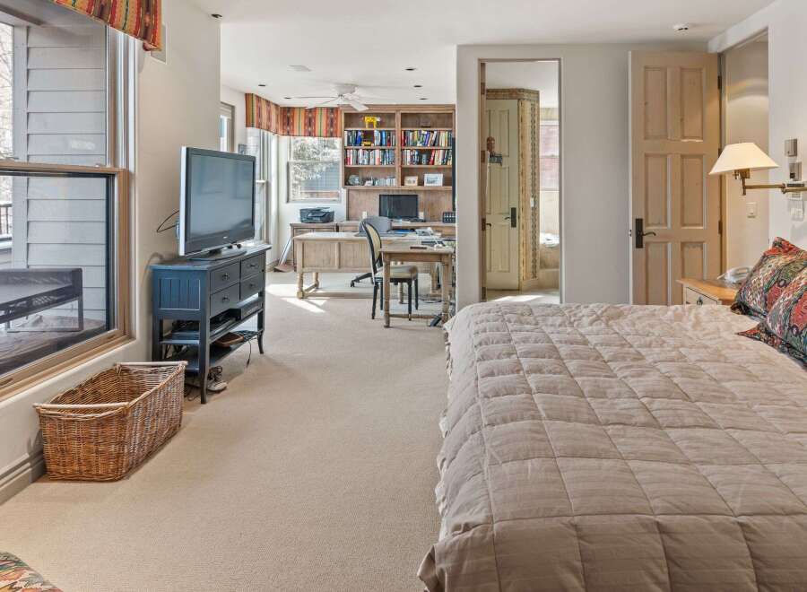 This stunning bedroom offers a serene retreat with its neutral color palette and ample natural light.