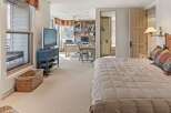This stunning bedroom offers a serene retreat with its neutral color palette and ample natural light.