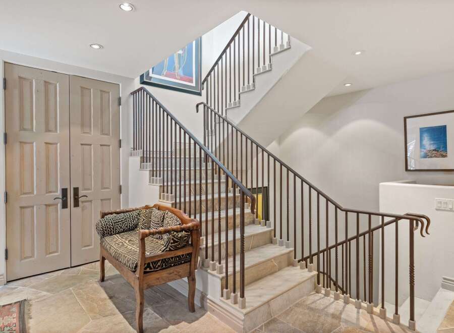 This stunning property boasts a grand staircase with elegant wrought iron railings, creating a sophisticated focal point.