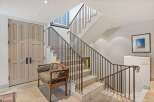 This stunning property boasts a grand staircase with elegant wrought iron railings, creating a sophisticated focal point.
