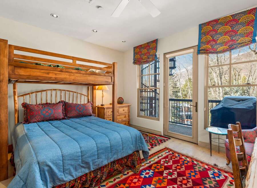 This cozy bedroom features a unique bunk bed design, perfect for families or guests.