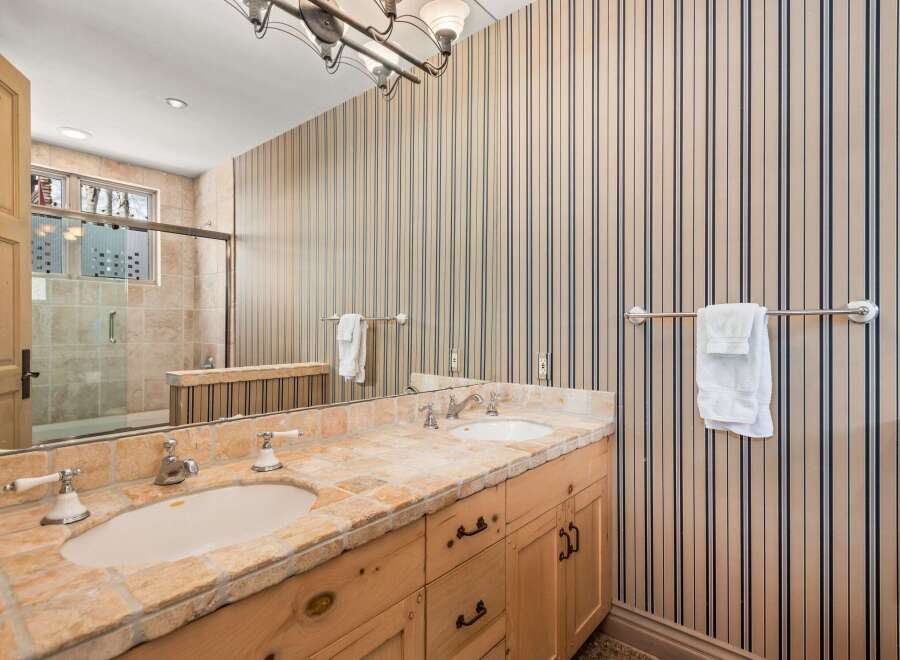 This stunning bathroom boasts a luxurious design with a double vanity and a beautiful stone countertop.