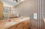 This stunning bathroom boasts a luxurious design with a double vanity and a beautiful stone countertop.