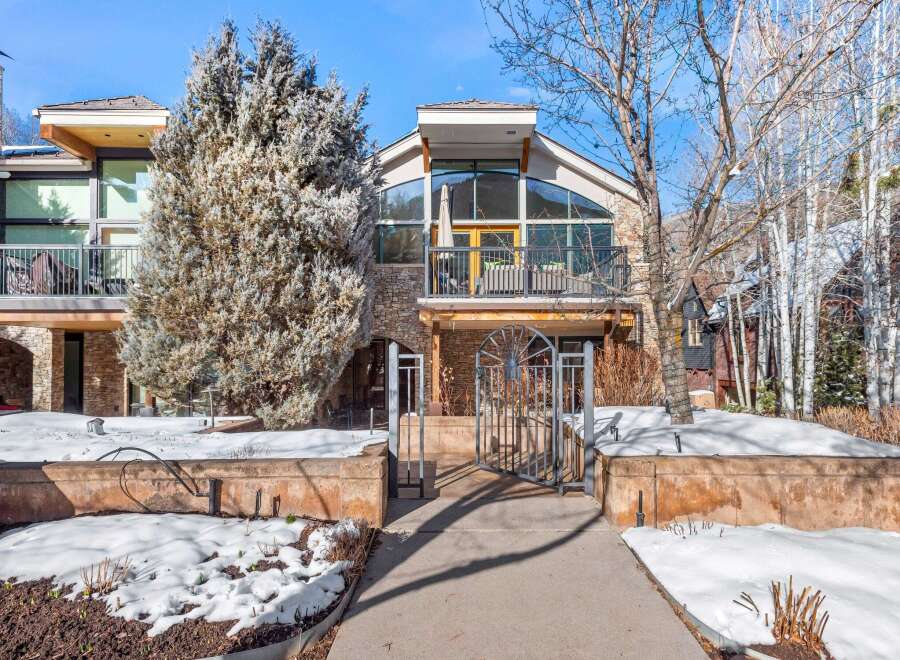 This stunning property boasts a modern design with a stone facade and large windows, offering breathtaking views.