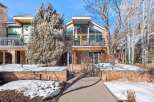 This stunning property boasts a modern design with a stone facade and large windows, offering breathtaking views.