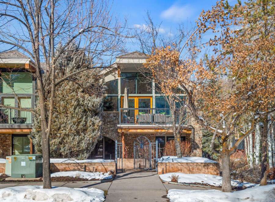 This stunning property boasts a unique architectural design with a stone facade and large windows, creating a modern and inviting atmosphere.