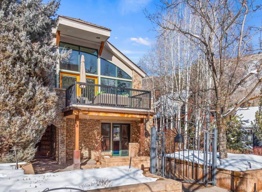 This stunning property boasts a unique architectural design with a stone facade and a balcony offering breathtaking views.
