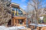 This stunning property boasts a unique architectural design with a stone facade and a balcony offering breathtaking views.