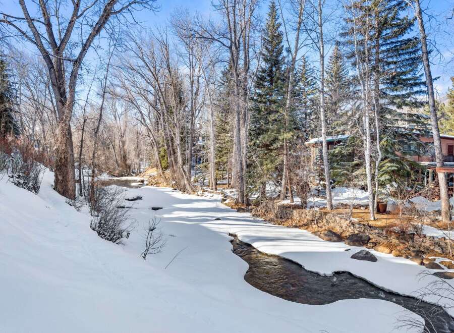 Nestled along a serene, partially frozen river, this property offers a picturesque winter landscape.