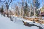 Nestled along a serene, partially frozen river, this property offers a picturesque winter landscape.