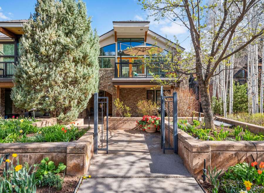 Experience luxury mountain living in this stunning property featuring a modern architectural design with expansive windows and a spacious balcony perfect for enjoying the serene surroundings.