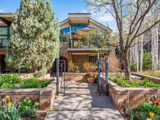 Experience luxury mountain living in this stunning property featuring a modern architectural design with expansive windows and a spacious balcony perfect for enjoying the serene surroundings.