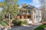 Experience luxury mountain living in this stunning home featuring a striking stone facade and expansive windows that capture breathtaking views.
