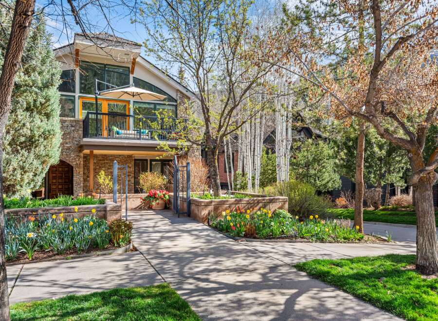 Experience luxury living in this stunning home, featuring a spacious balcony with an umbrella for outdoor relaxation and expansive windows that flood the interior with natural light.