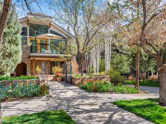 Experience luxury living in this stunning home, featuring a spacious balcony with an umbrella for outdoor relaxation and expansive windows that flood the interior with natural light.