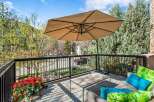 Enjoy the outdoors on this charming balcony, complete with a large umbrella for shade and comfortable seating.