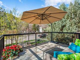 Enjoy the outdoors on this charming balcony, complete with a large umbrella for shade and comfortable seating.