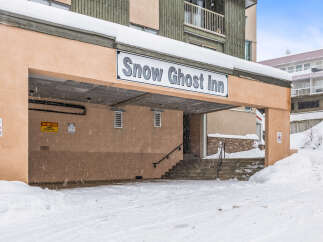The Snow Ghost Inn, nestled in a snowy landscape, offers a cozy retreat.