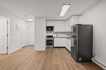 This modern kitchen boasts sleek white cabinetry and stainless steel appliances, creating a bright and inviting space.