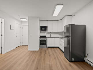 This modern kitchen boasts sleek white cabinetry and stainless steel appliances, creating a bright and inviting space.