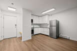 Discover modern living in this stylish apartment featuring a well-equipped kitchen with sleek white cabinetry and stainless steel appliances.