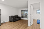 Discover modern living in this stylish apartment featuring a sleek black leather sofa and beautiful hardwood floors.
