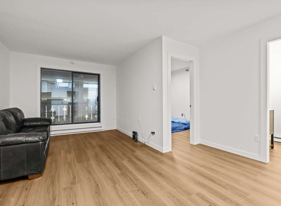 This stunning property boasts a modern living space with sleek hardwood floors and bright, white walls.