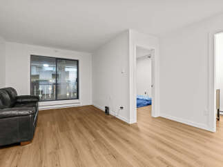 This stunning property boasts a modern living space with sleek hardwood floors and bright, white walls.