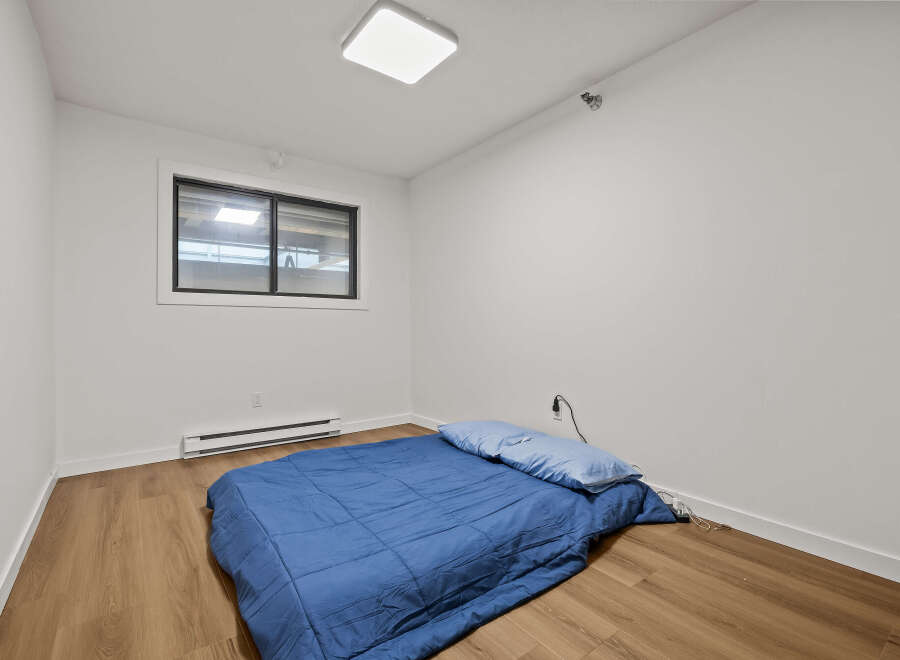 This cozy bedroom features a comfortable bed with a blue comforter and pillows, perfect for a relaxing night's sleep.