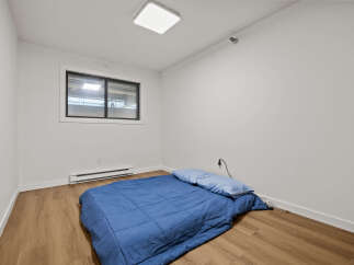 This cozy bedroom features a comfortable bed with a blue comforter and pillows, perfect for a relaxing night's sleep.