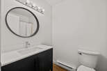This modern bathroom features a sleek black vanity with a pristine white countertop, offering ample storage and a stylish design.