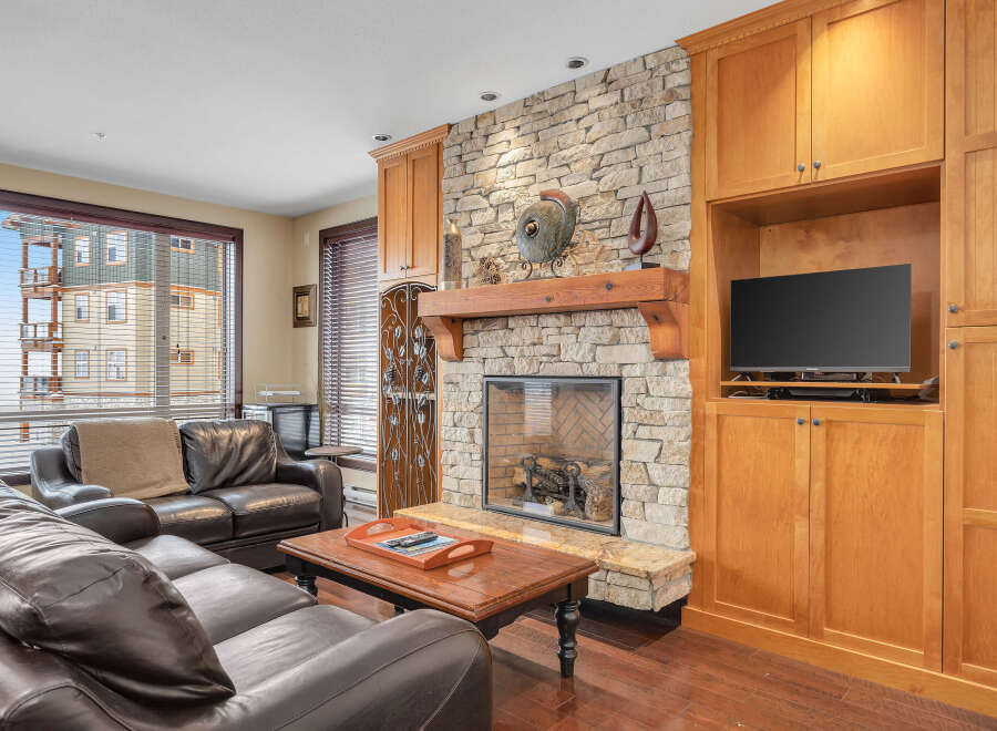 This stunning living room features a cozy fireplace with a stone surround, perfect for those chilly evenings.