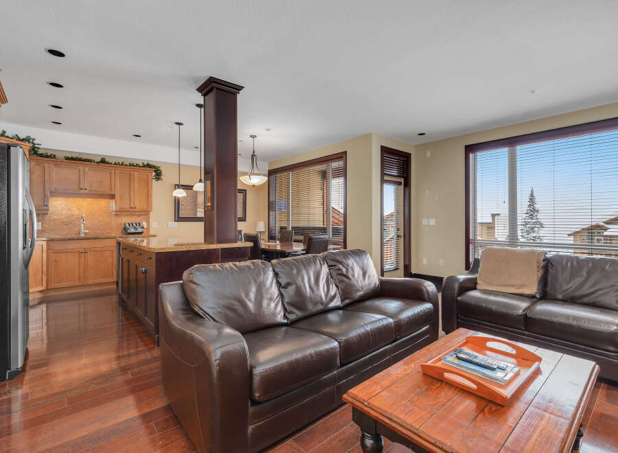 This stunning property features a spacious living area with a comfortable leather sofa, perfect for relaxing.