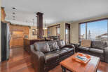 This stunning property features a spacious living area with a comfortable leather sofa, perfect for relaxing.