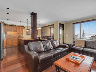 This stunning property features a spacious living area with a comfortable leather sofa, perfect for relaxing.