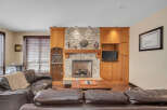 This stunning living room boasts a cozy fireplace with a stone facade, creating a warm and inviting atmosphere.