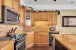 This stunning kitchen boasts beautiful wooden cabinetry and granite countertops, creating a warm and inviting atmosphere.