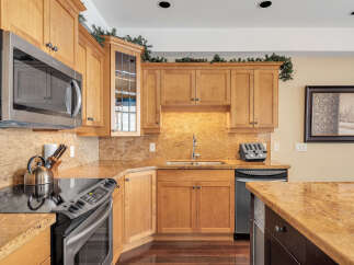 This stunning kitchen boasts beautiful wooden cabinetry and granite countertops, creating a warm and inviting atmosphere.
