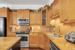 This stunning kitchen boasts beautiful wooden cabinetry and granite countertops, creating a warm and inviting atmosphere.