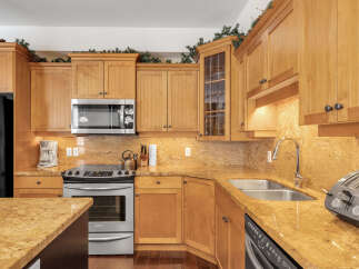 This stunning kitchen boasts beautiful wooden cabinetry and granite countertops, creating a warm and inviting atmosphere.