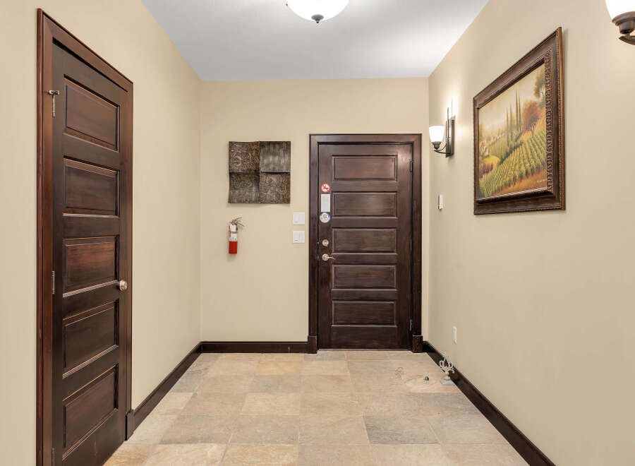 This stunning property features a welcoming hallway with elegant dark wood doors.