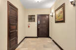 This stunning property features a welcoming hallway with elegant dark wood doors.