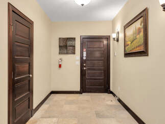 This stunning property features a welcoming hallway with elegant dark wood doors.