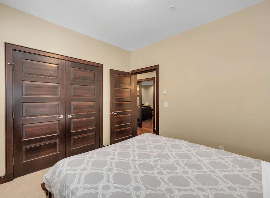 Step into a beautifully designed bedroom featuring rich, dark wood doors that add a touch of elegance.