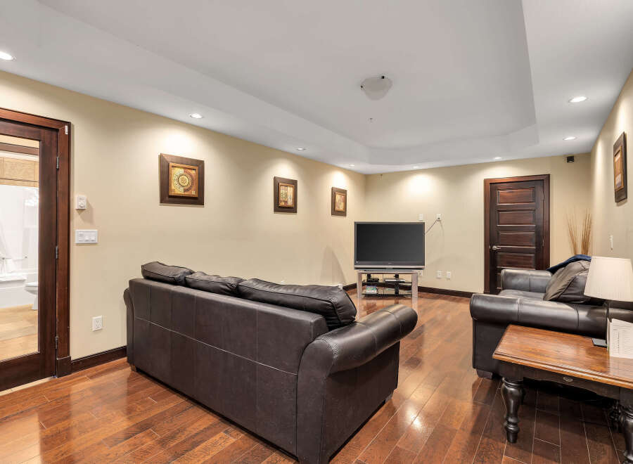 This stunning living space boasts a modern design with a comfortable leather sofa and a sleek entertainment center.